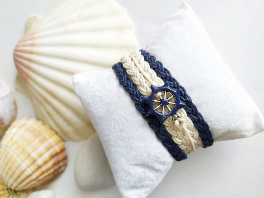 Pulsera estilo náutico en algodón azul y blanco con adorno de un timón. Raquel Jiménez  Artesanía