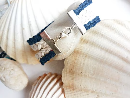 Pulsera estilo náutico en algodón azul y blanco con adorno de un timón. Raquel Jiménez  Artesanía