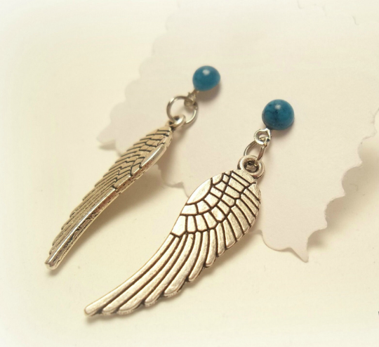 Pendientes largos con adorno en forma de alas y bolas color turquesa. Los pendientes son muy románticos con su adorno de alas de ángel, llevan cierre de mariposa a presión.