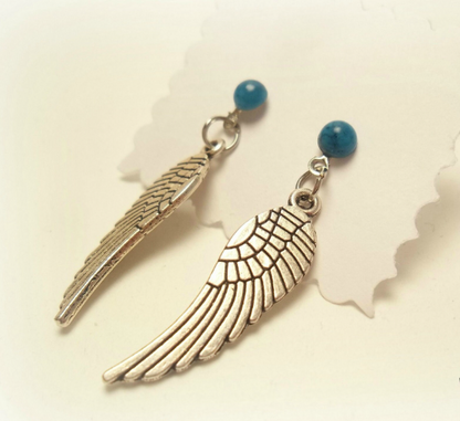 Pendientes largos con adorno en forma de alas y bolas color turquesa. Los pendientes son muy románticos con su adorno de alas de ángel, llevan cierre de mariposa a presión.