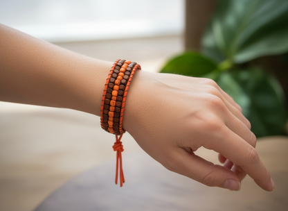 Pulsera de cuero con cuentas de madera naranja y marrón.