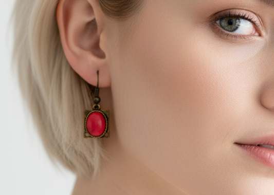 Pendientes bohemios y románticos de estilo vintage en color oro viejo adornados con una bola coral rojo natural de extracción protegida.