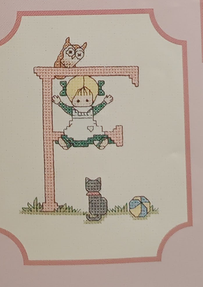 Graphic and pattern of the complete alphabet of 52 cross-stitch letters with designs for boys and girls