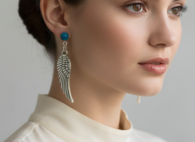 Pendientes largos con adorno en forma de alas y bolas color turquesa. Los pendientes son muy románticos con su adorno de alas de ángel, llevan cierre de mariposa a presión.
