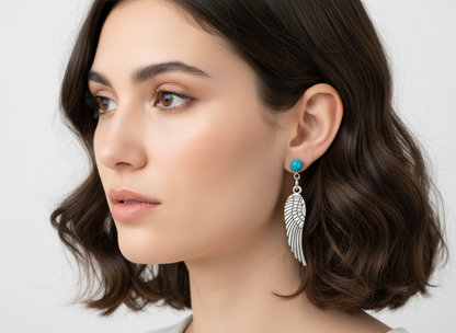 Pendientes largos con adorno en forma de alas y bolas color turquesa. Los pendientes son muy románticos con su adorno de alas de ángel, llevan cierre de mariposa a presión.