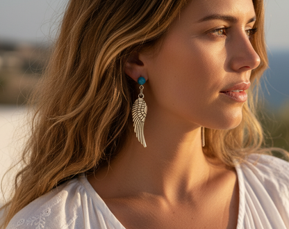 Pendientes largos con adorno en forma de alas y bolas color turquesa. Los pendientes son muy románticos con su adorno de alas de ángel, llevan cierre de mariposa a presión.