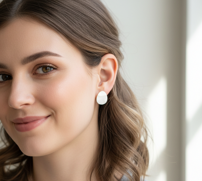 Pendientes tipo botón de nácar natural, son pequeños y discretos con forma de gota o lagrima, son naturales y por lo tanto no son exactamente iguales en&nbsp; color, cualquier diferencia entre ellas no es un fallo es la demostración de que son totalmente naturales.