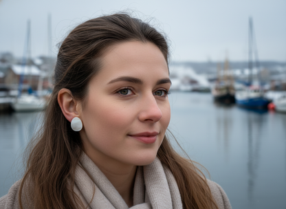 Pendientes tipo botón de nácar natural, son pequeños y discretos con forma de gota o lagrima, son naturales y por lo tanto no son exactamente iguales en&nbsp; color, cualquier diferencia entre ellas no es un fallo es la demostración de que son totalmente naturales.