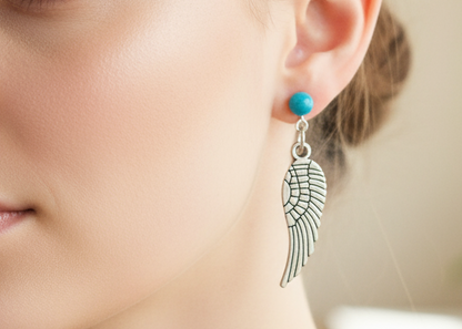 Pendientes largos con adorno en forma de alas y bolas color turquesa. Los pendientes son muy románticos con su adorno de alas de ángel, llevan cierre de mariposa a presión.