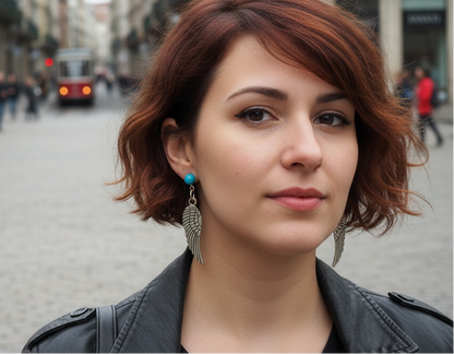 Pendientes largos con adorno en forma de alas y bolas color turquesa. Los pendientes son muy románticos con su adorno de alas de ángel, llevan cierre de mariposa a presión.