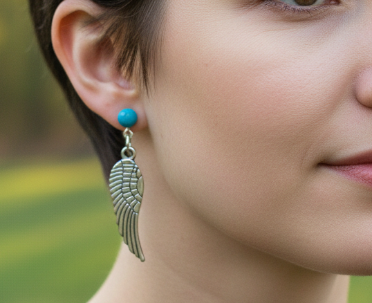 Pendientes largos con adorno en forma de alas y bolas color turquesa. Los pendientes son muy románticos con su adorno de alas de ángel, llevan cierre de mariposa a presión.