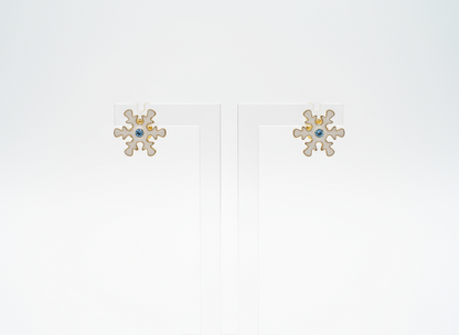 Pendientes de botón con adorno de copo de nieve, con cristal central en tonos azules.