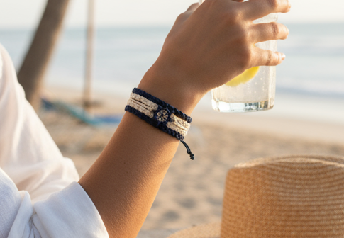 Pulsera estilo náutico en algodón azul y blanco con adorno de un timón. Raquel Jiménez  Artesanía 