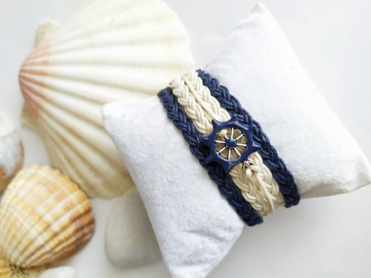 Pulsera estilo náutico en algodón azul y blanco con adorno de un timón. Raquel Jiménez  Artesanía 