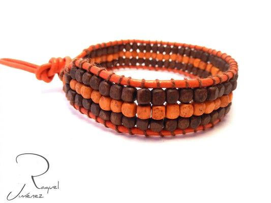 Leather bracelet with orange and brown wooden beads.