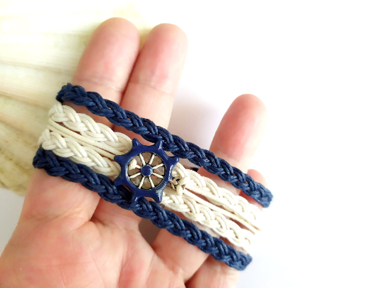 Pulsera estilo náutico en algodón azul y blanco con adorno de un timón. Raquel Jiménez Artesanía