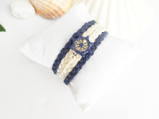 Pulsera estilo náutico en algodón azul y blanco con adorno de un timón. Raquel Jiménez Artesanía